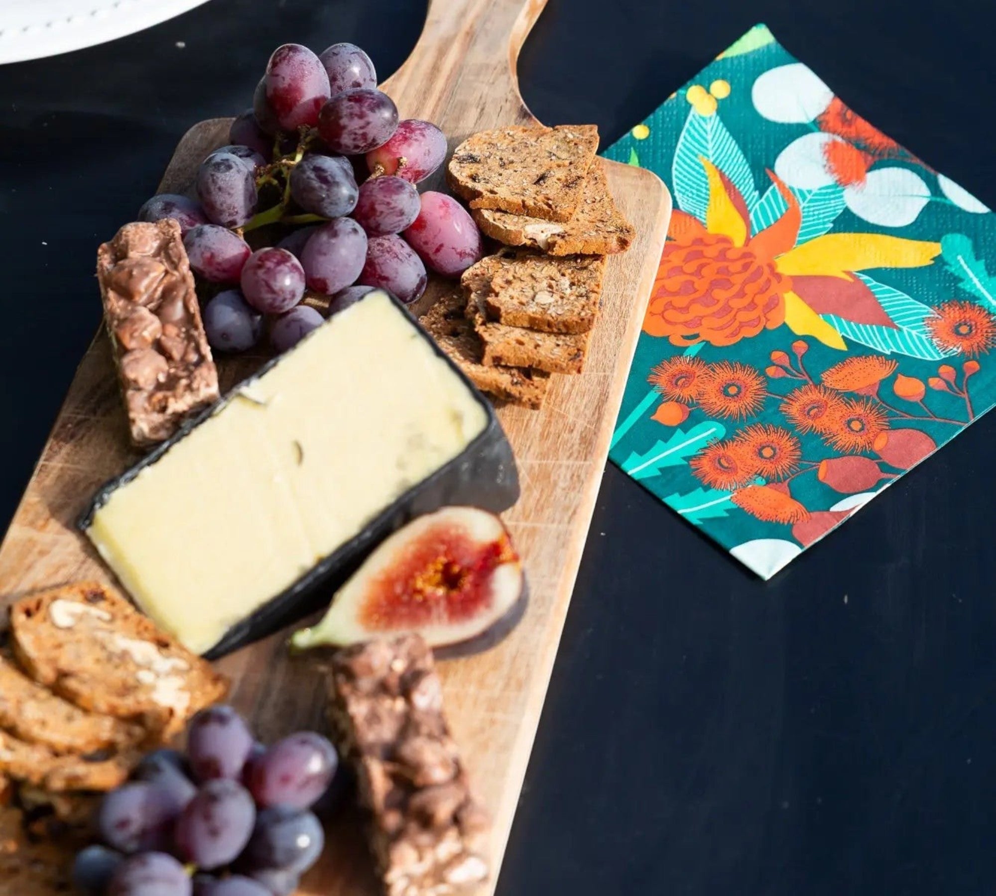 Allgifts Australia 3-ply paper napkins featuring a colourful Australian botanical print on a charcuterie board.