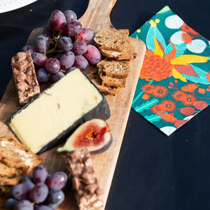 Allgifts Australia 3-ply paper napkins featuring a colourful Australian botanical print on a charcuterie board.