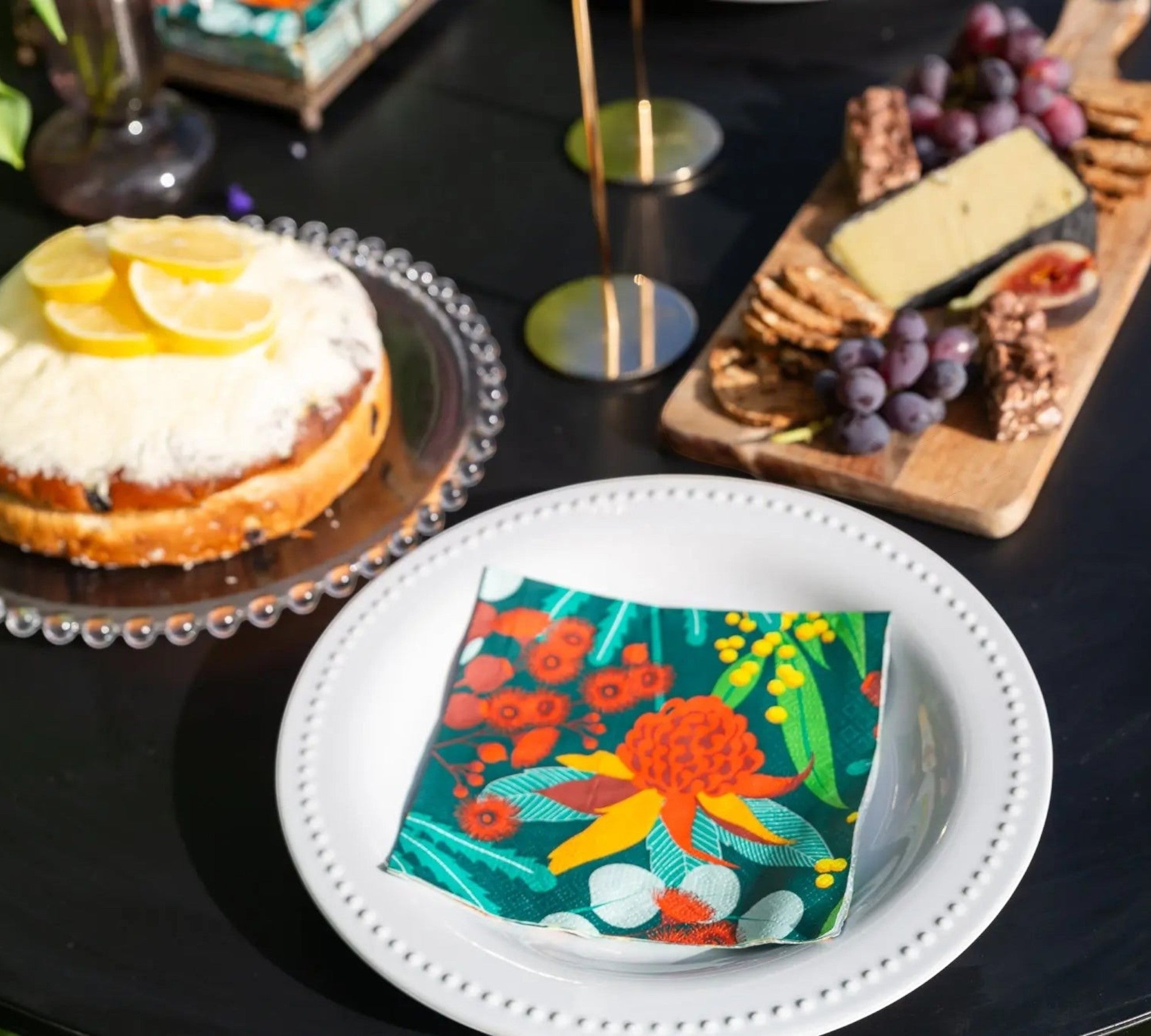 Allgifts Australia paper napkins featuring a vibrant Australian botanical print on a white plate at a table setting.